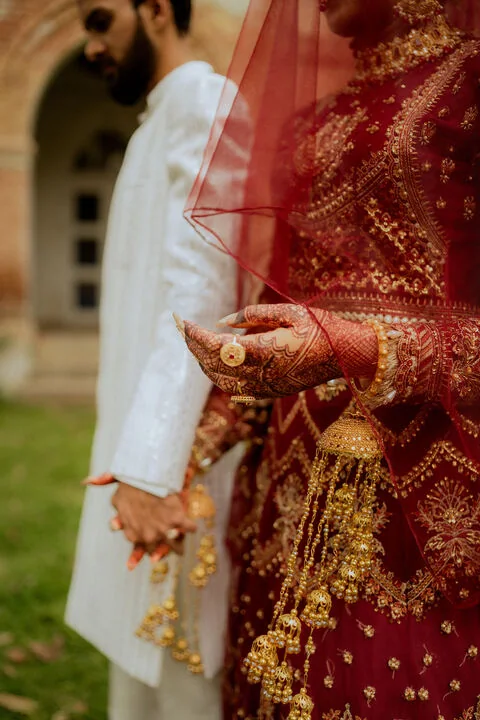Couple holding hands with traditional wedding henna