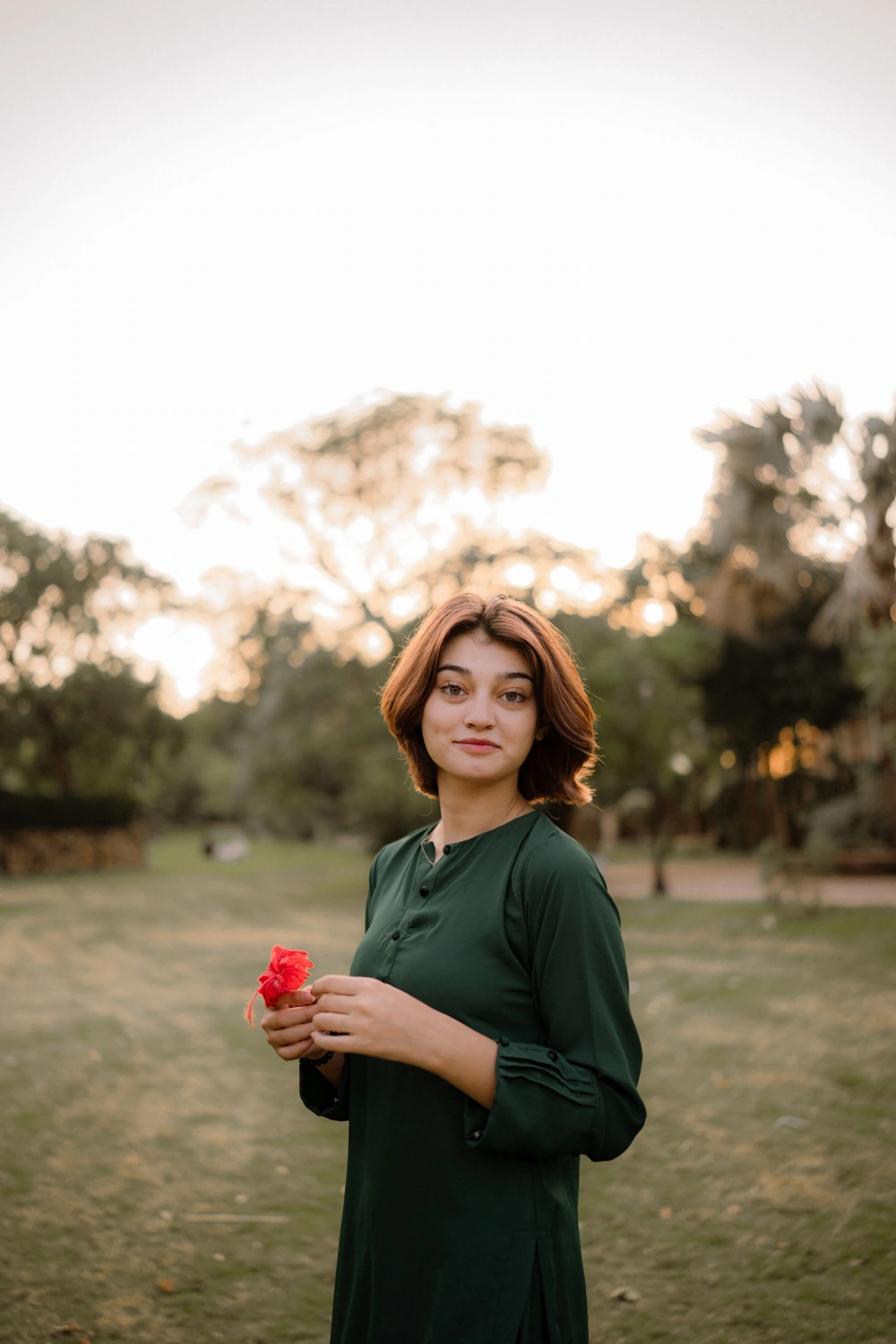 Portrait in a garden holding a red rose